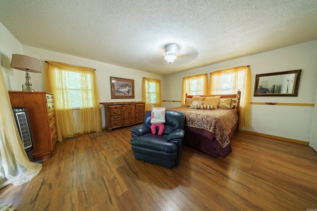 bedroom featuring a textured ceiling and dark hardwood / wood-style floors