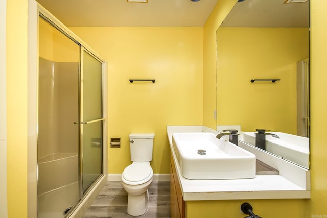 bathroom with a shower with door, toilet, hardwood / wood-style flooring, and vanity