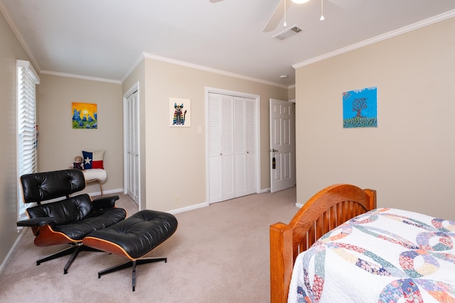 bedroom featuring light colored carpet, two closets, crown molding, and ceiling fan