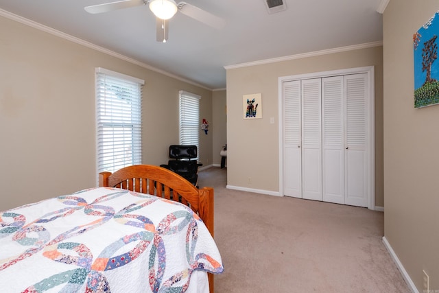 bedroom featuring light colored carpet, ornamental molding, a closet, and ceiling fan