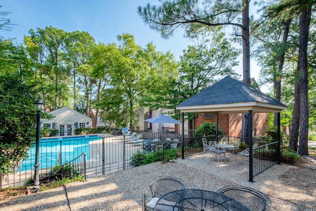 view of patio featuring a community pool and a gazebo