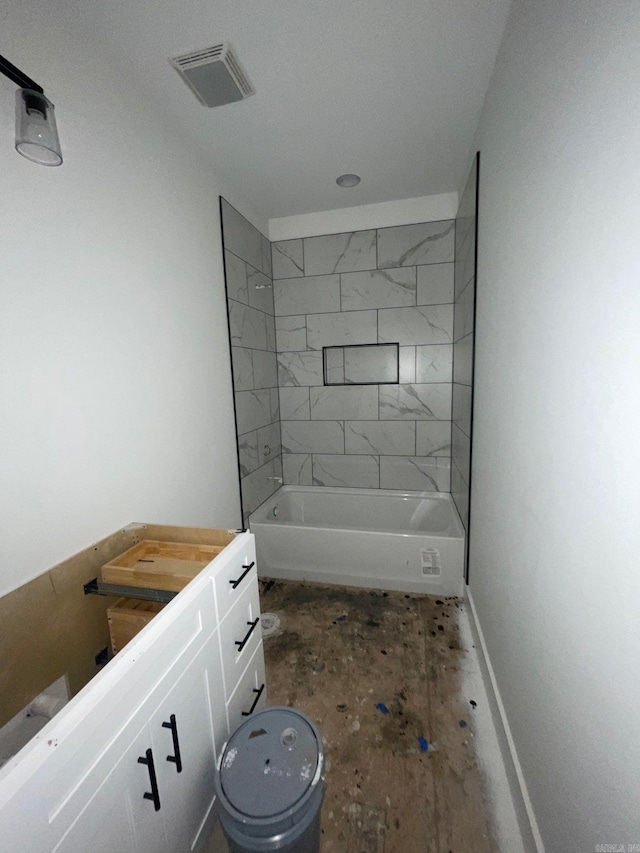 bathroom featuring tiled shower / bath and vanity