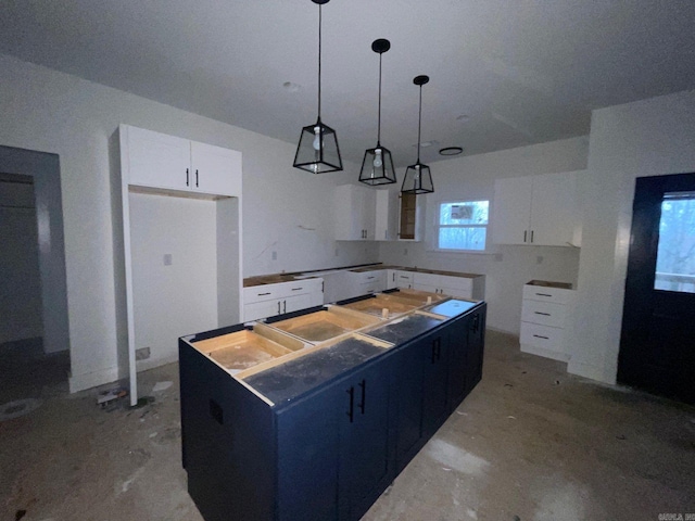 kitchen with hanging light fixtures, a kitchen island, and white cabinets