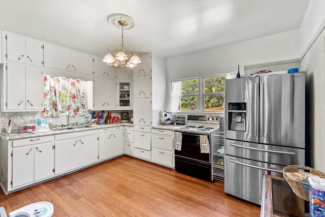 kitchen featuring electric range oven, tasteful backsplash, a sink, and stainless steel fridge with ice dispenser