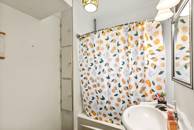 full bath featuring shower / tub combo with curtain and a sink