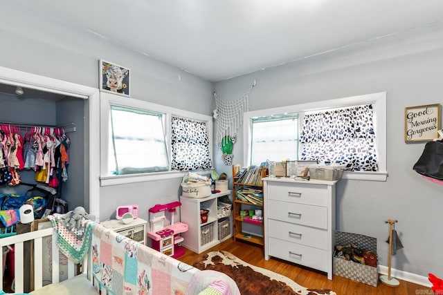 bedroom featuring a closet, baseboards, and wood finished floors