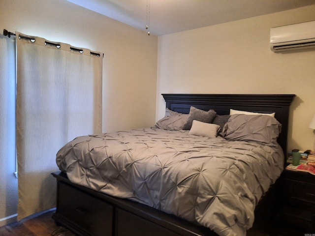 bedroom featuring dark hardwood / wood-style flooring and a wall mounted air conditioner