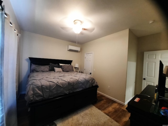 bedroom featuring ceiling fan, a wall unit AC, and wood-type flooring