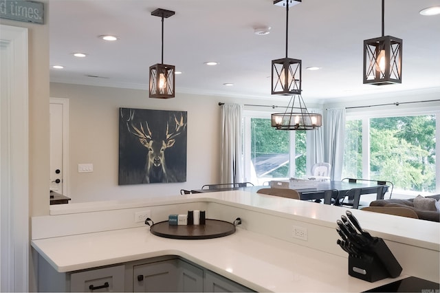 kitchen with gray cabinetry, a notable chandelier, crown molding, and hanging light fixtures