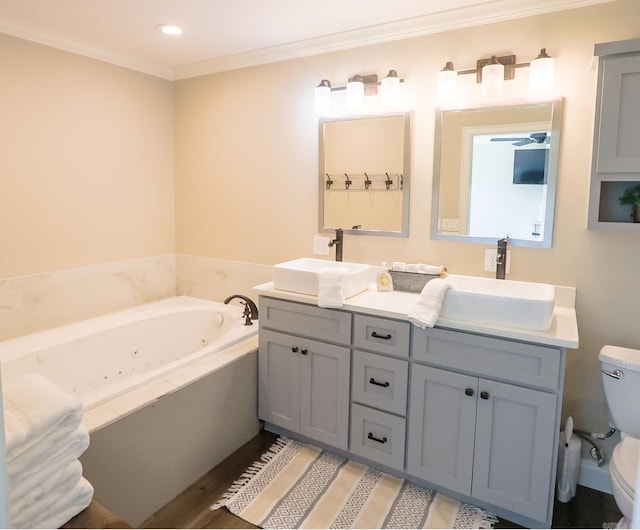 bathroom featuring vanity, crown molding, tiled bath, and toilet