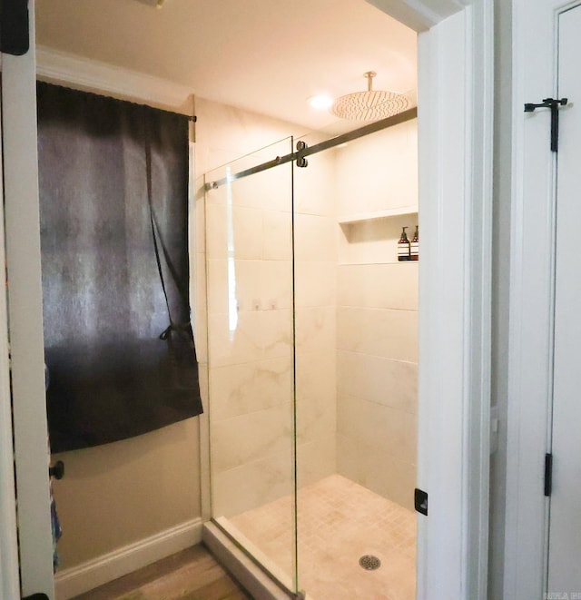 bathroom with hardwood / wood-style floors and a shower with shower door