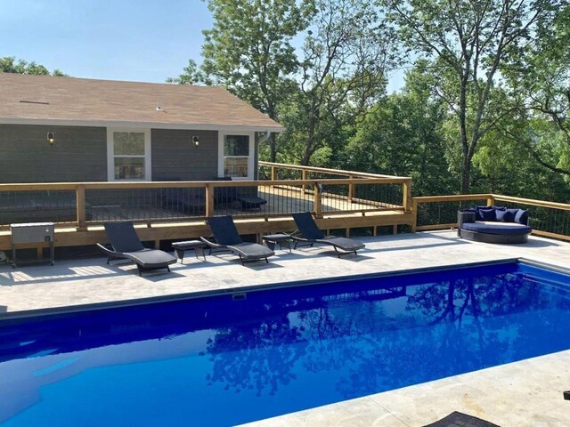 view of swimming pool featuring a patio, outdoor lounge area, and a wooden deck