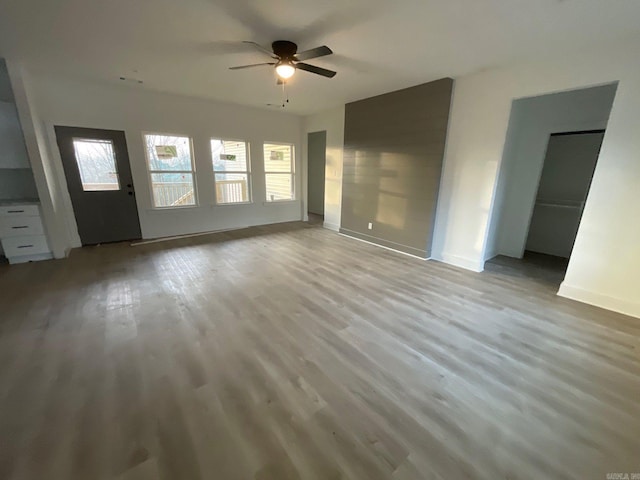 unfurnished living room featuring ceiling fan and light wood-type flooring