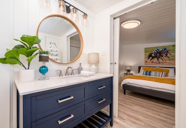 bathroom featuring crown molding, hardwood / wood-style floors, and vanity