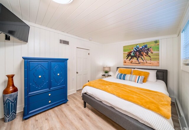 bedroom with light wood-type flooring, crown molding, and wooden ceiling