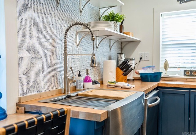 kitchen with wood counters and blue cabinetry