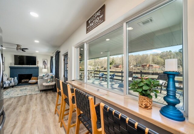 dining area with a wealth of natural light, light hardwood / wood-style flooring, and a fireplace