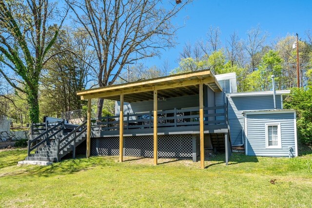 back of property featuring a wooden deck and a lawn