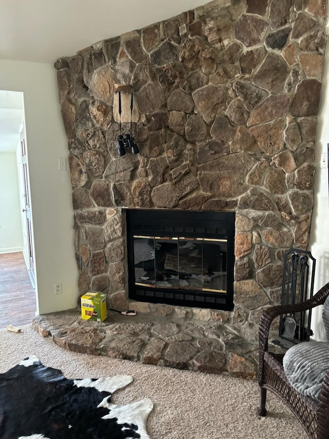 interior details featuring hardwood / wood-style floors and a stone fireplace