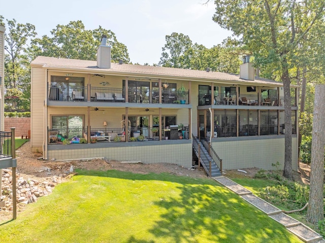 rear view of house with a balcony, a patio, and a lawn