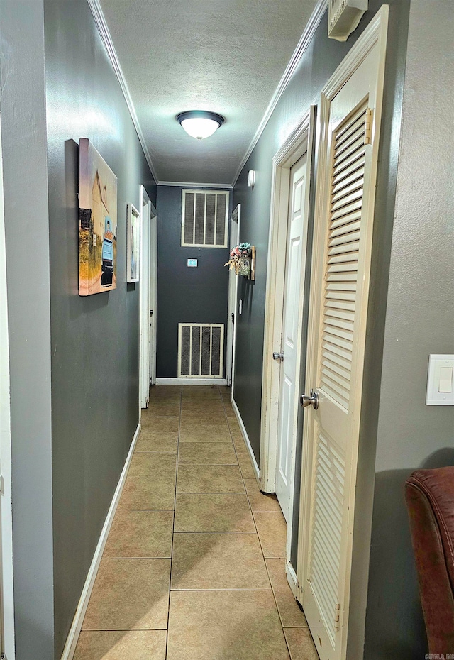 hall with crown molding, a textured ceiling, and light tile patterned floors