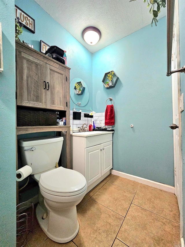 bathroom featuring a textured ceiling, tile patterned floors, toilet, tasteful backsplash, and vanity