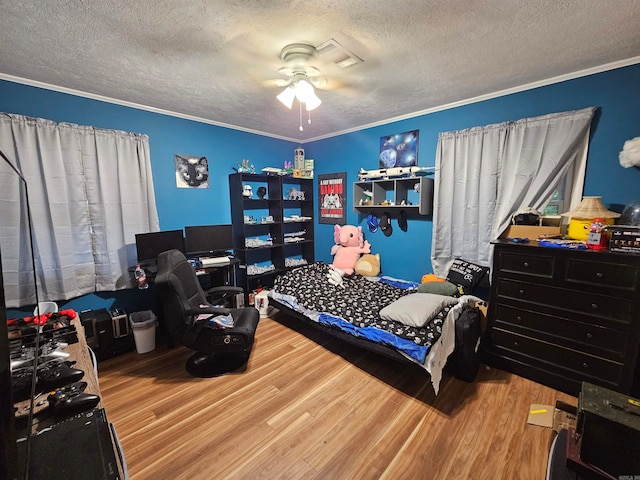 bedroom with a textured ceiling, crown molding, ceiling fan, and light hardwood / wood-style floors