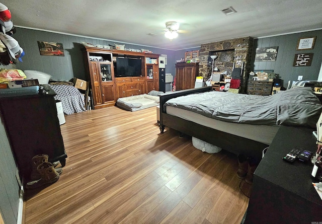 bedroom with hardwood / wood-style floors, ceiling fan, and a textured ceiling