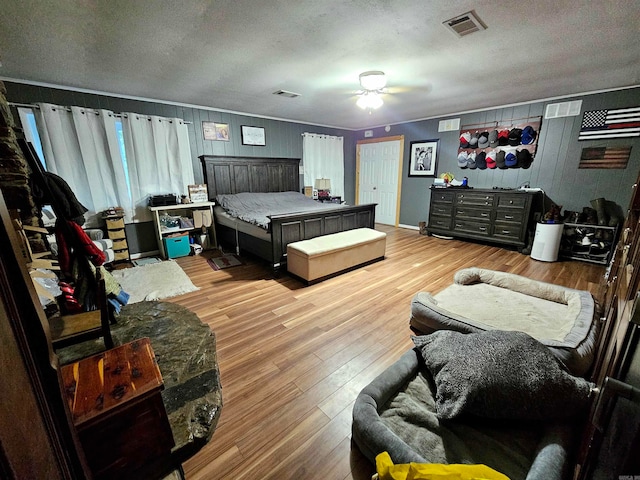 bedroom featuring light wood-type flooring, ceiling fan, and a textured ceiling