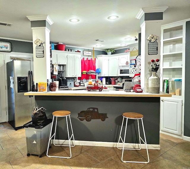 kitchen featuring a breakfast bar, stainless steel appliances, and white cabinets