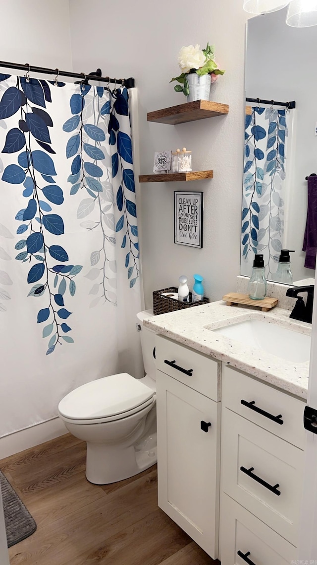 full bathroom with toilet, wood finished floors, and vanity