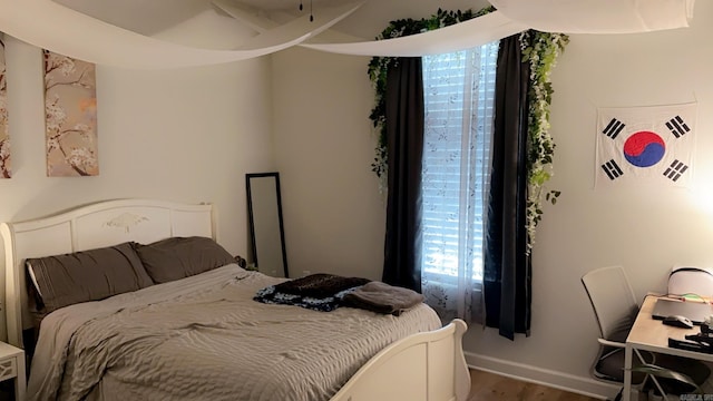 bedroom with wood finished floors and baseboards