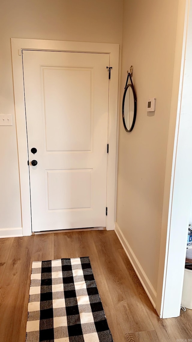 entryway featuring baseboards and wood finished floors