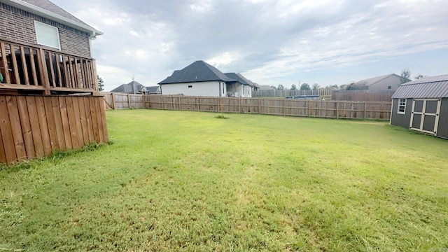 view of yard featuring a fenced backyard, an outdoor structure, and a storage unit