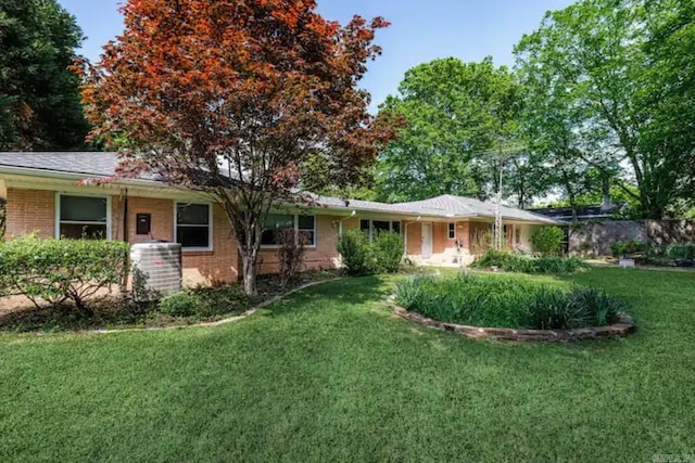 view of front of home featuring a front yard and central AC