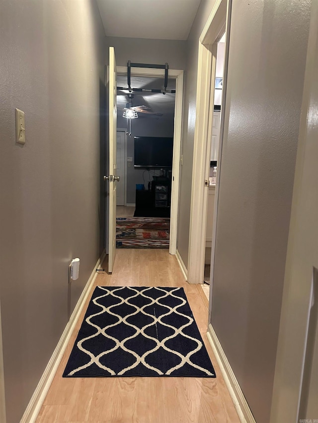 corridor with light hardwood / wood-style floors