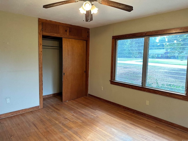 unfurnished bedroom with ceiling fan, a closet, and light wood-type flooring