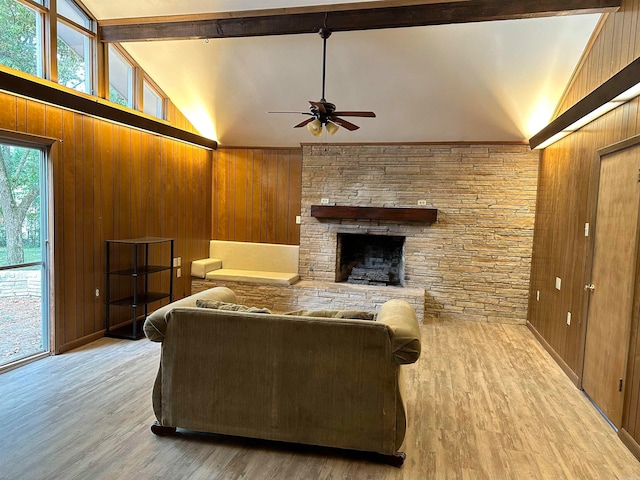 living room with a fireplace, hardwood / wood-style floors, beam ceiling, and ceiling fan