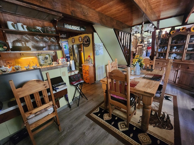 dining space featuring an inviting chandelier, dark hardwood / wood-style flooring, beamed ceiling, and wooden ceiling