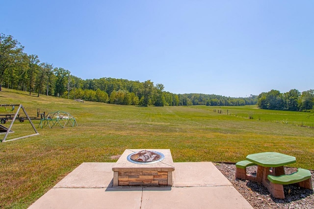 view of yard with a fire pit, a rural view, and a patio