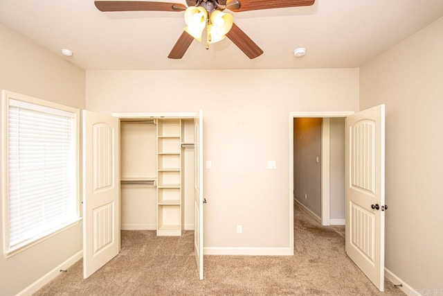 unfurnished bedroom with a closet, light colored carpet, and ceiling fan