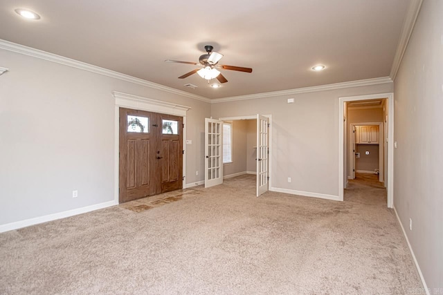 carpeted entrance foyer featuring crown molding and ceiling fan