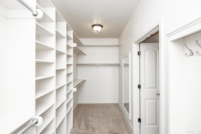 walk in closet featuring light colored carpet