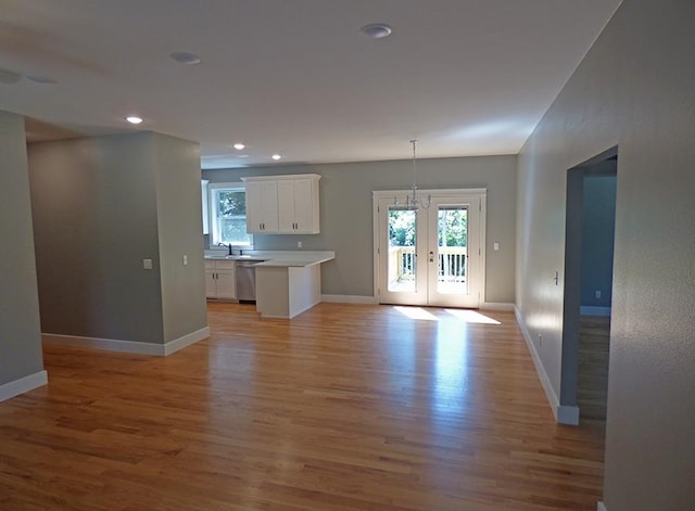 unfurnished living room featuring french doors, sink, and light wood-type flooring