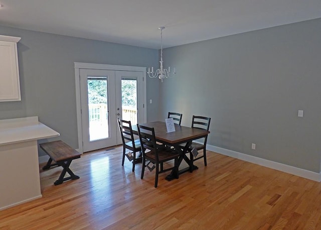 dining room featuring french doors, light hardwood / wood-style floors, and a chandelier