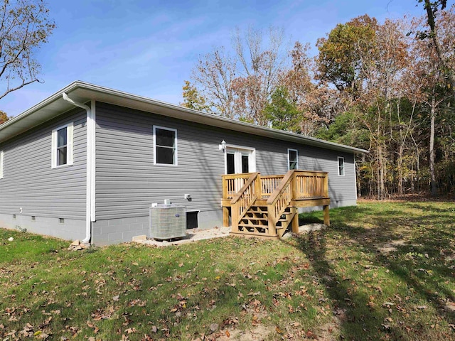 rear view of property with a wooden deck, a yard, and central AC unit