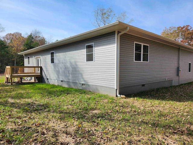 view of side of property with a wooden deck and a lawn