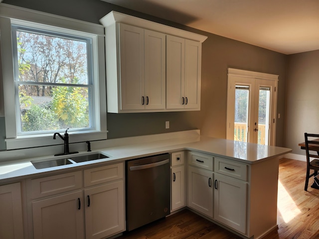 kitchen with sink, dishwasher, kitchen peninsula, and a healthy amount of sunlight