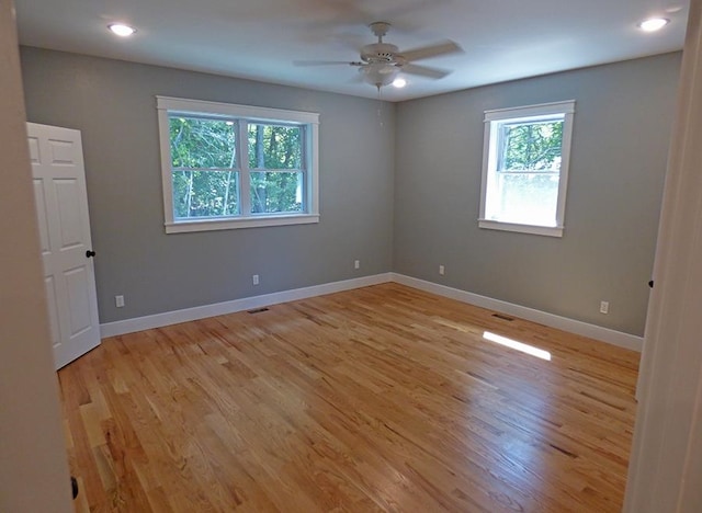 unfurnished room with ceiling fan, light hardwood / wood-style floors, and plenty of natural light