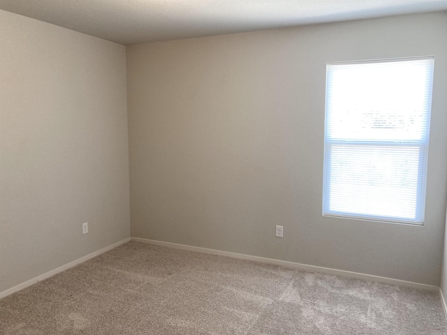 carpeted spare room with baseboards